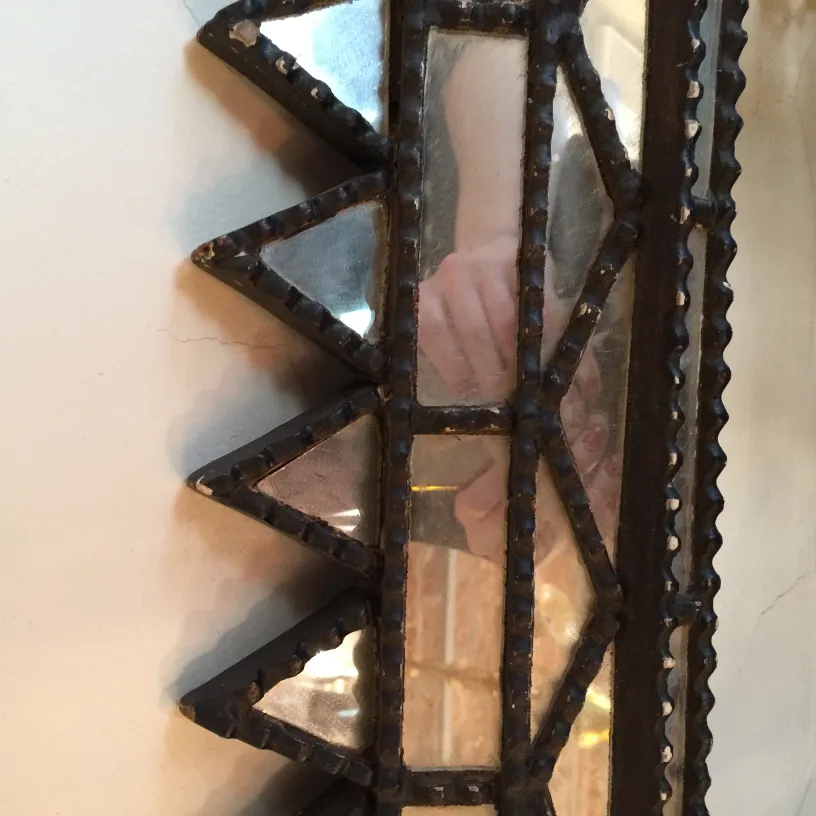 antique decorative mirror with an intricate frame, reflected hand