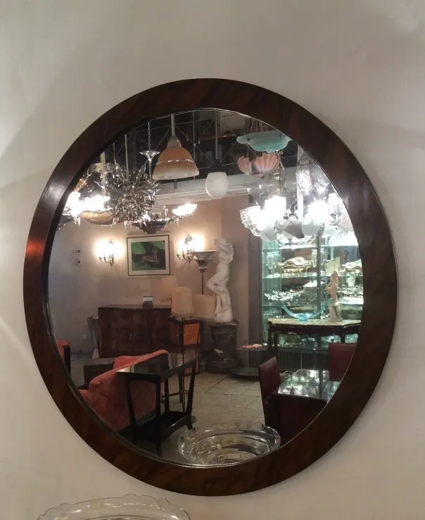 espelho redondo antigo na parede com luzes e decorações