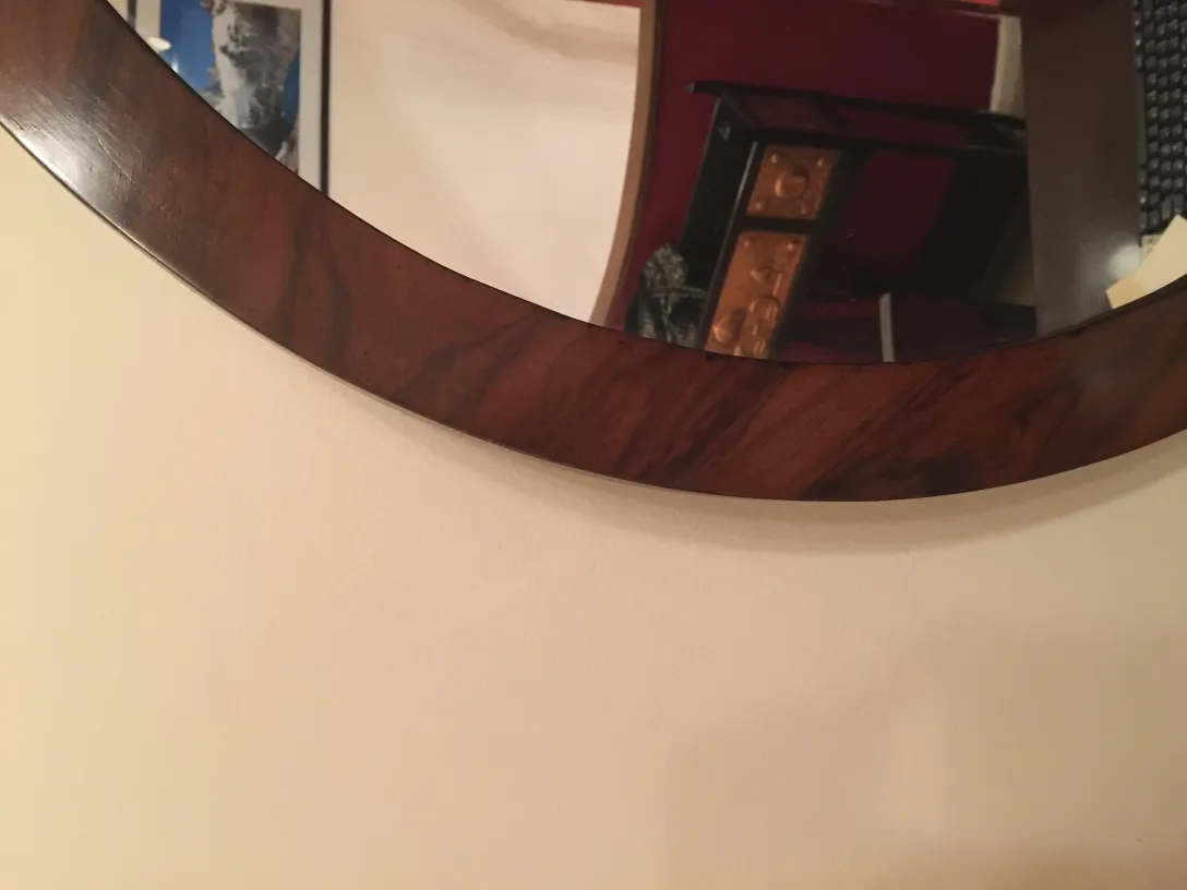 antique round mirror on the wall with decoration