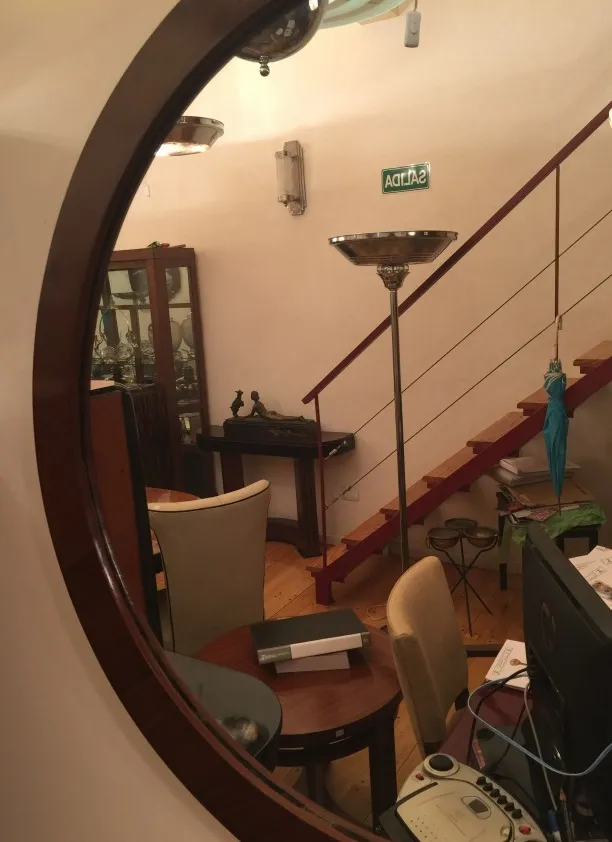 Antique decorative mirror reflecting a cozy room.