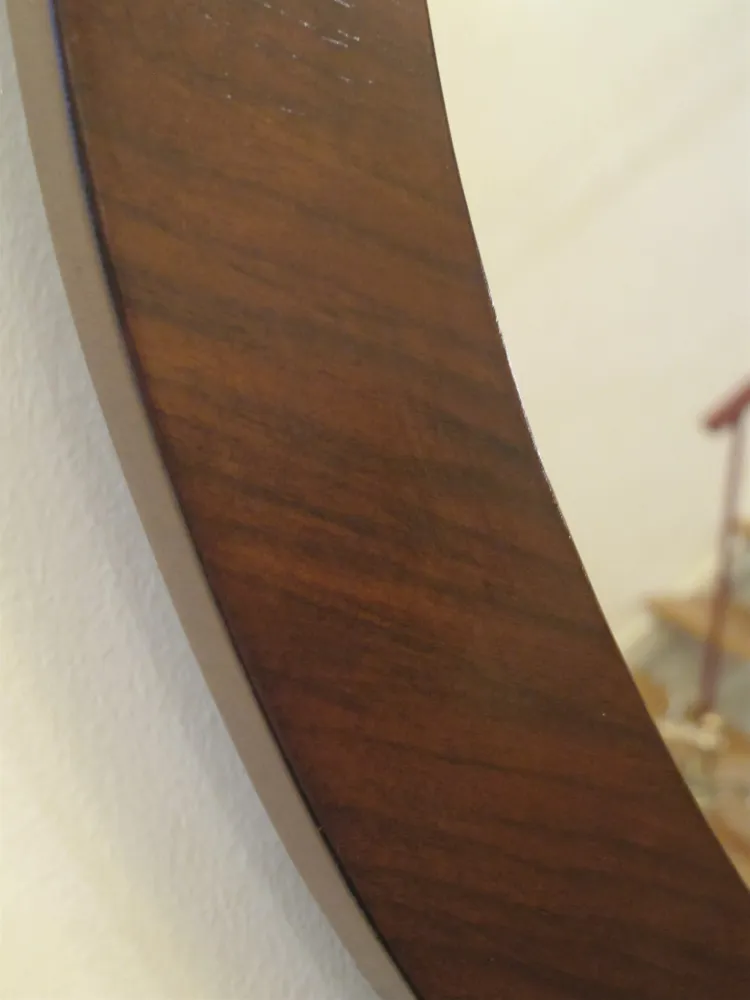 specchio antico con cornice decorativa su una parete chiara