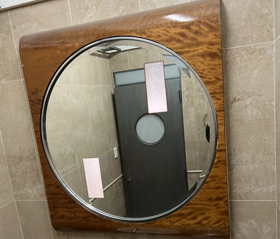 antique round mirror in a bathroom with fixtures