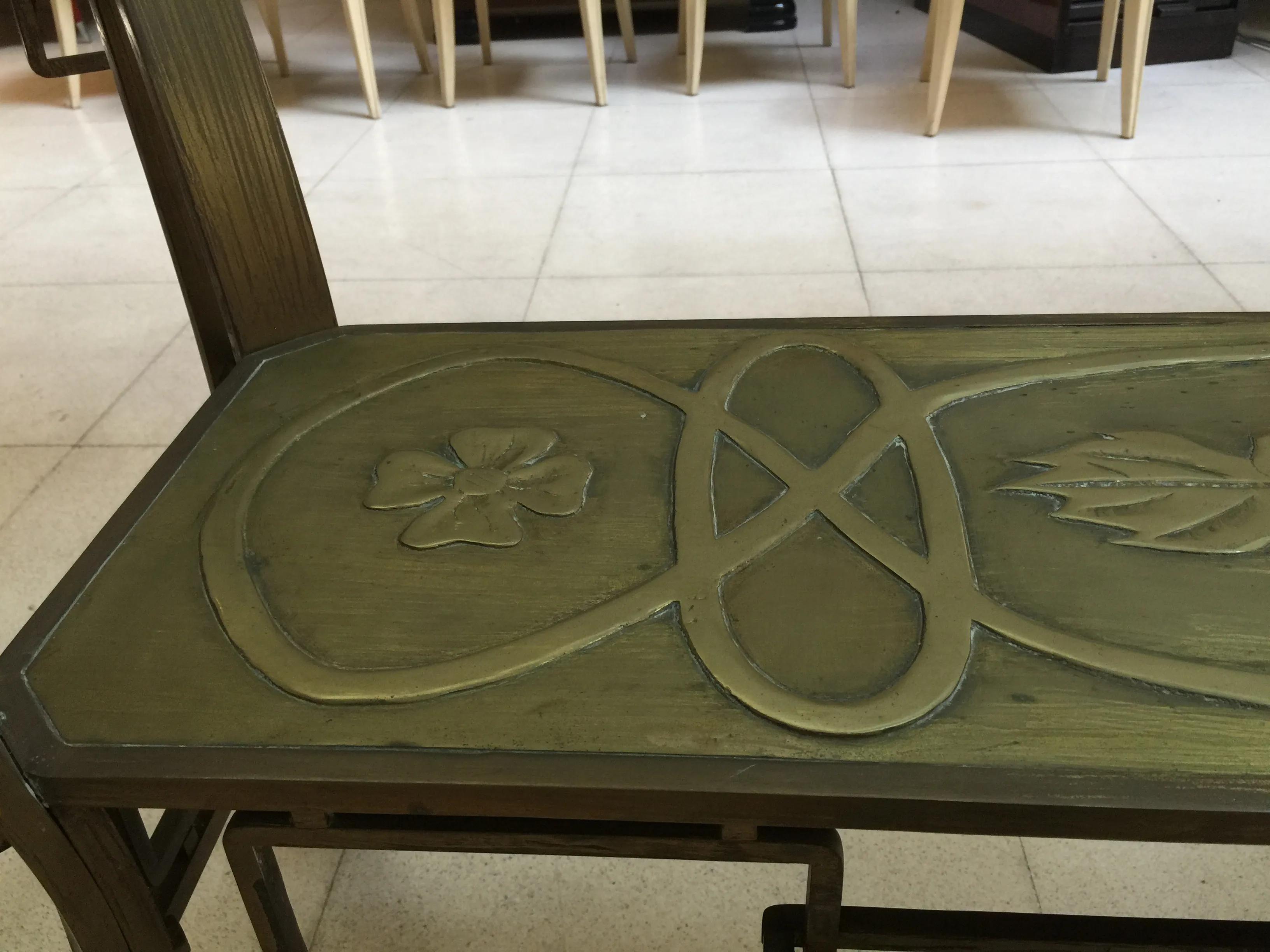 Mesa antigua de comedor con detalles florales, ambiente cálido.