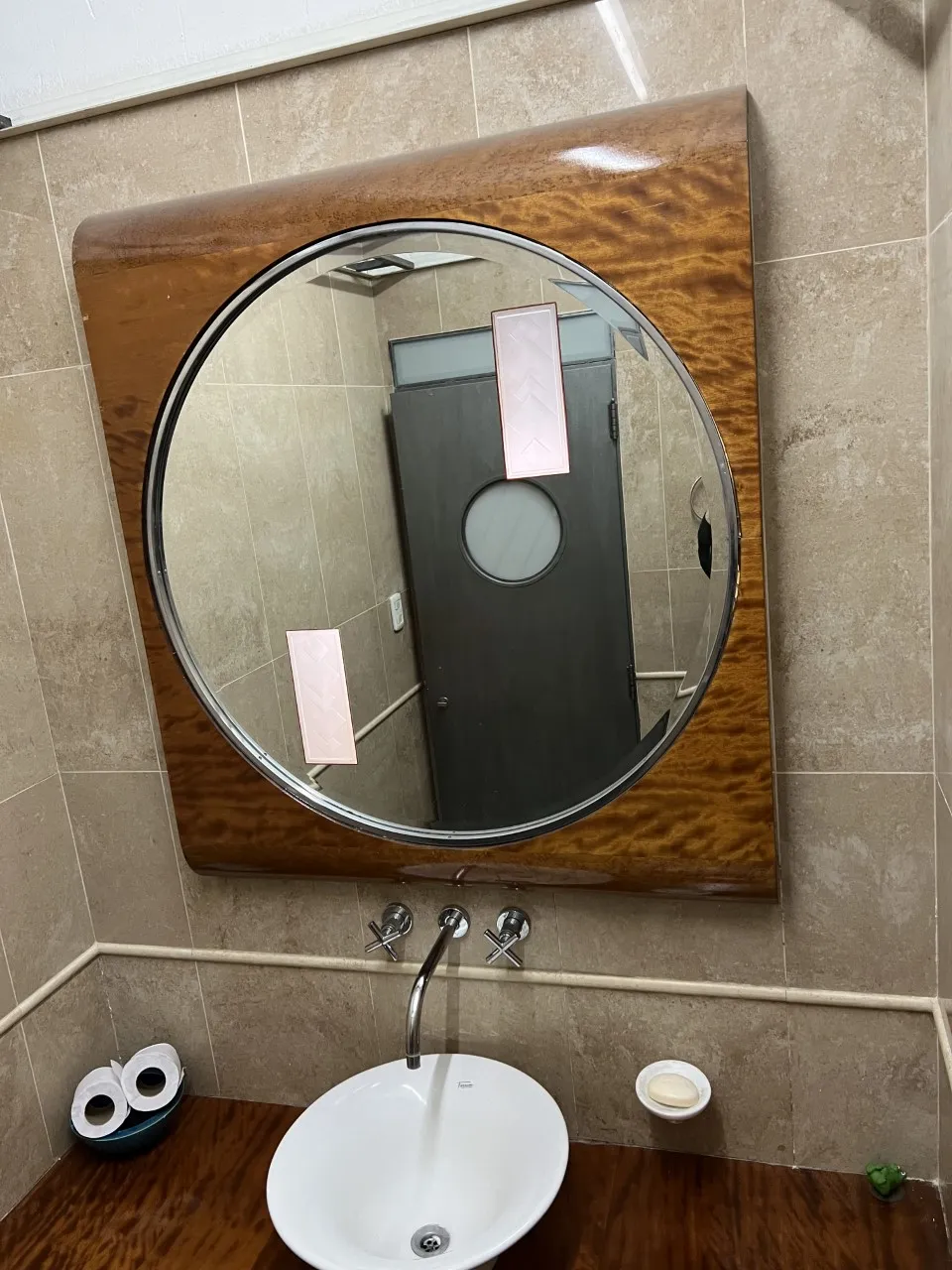 miroir rond ancien avec cadre marron dans la salle de bain