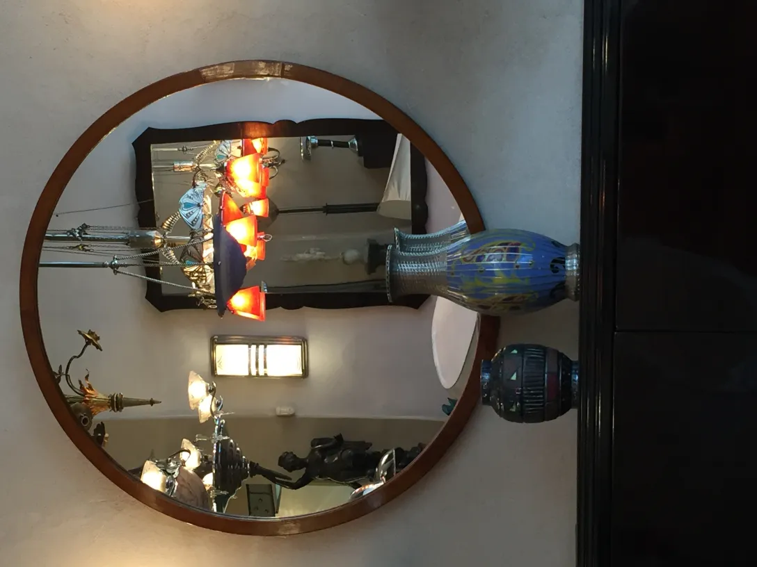 miroir antique rond avec des décorations visibles et des reflets dans un cadre élégant.