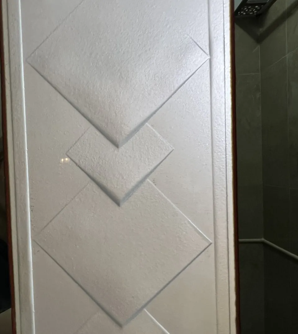 Antique mirror featuring embossed patterns, set in a modern environment.