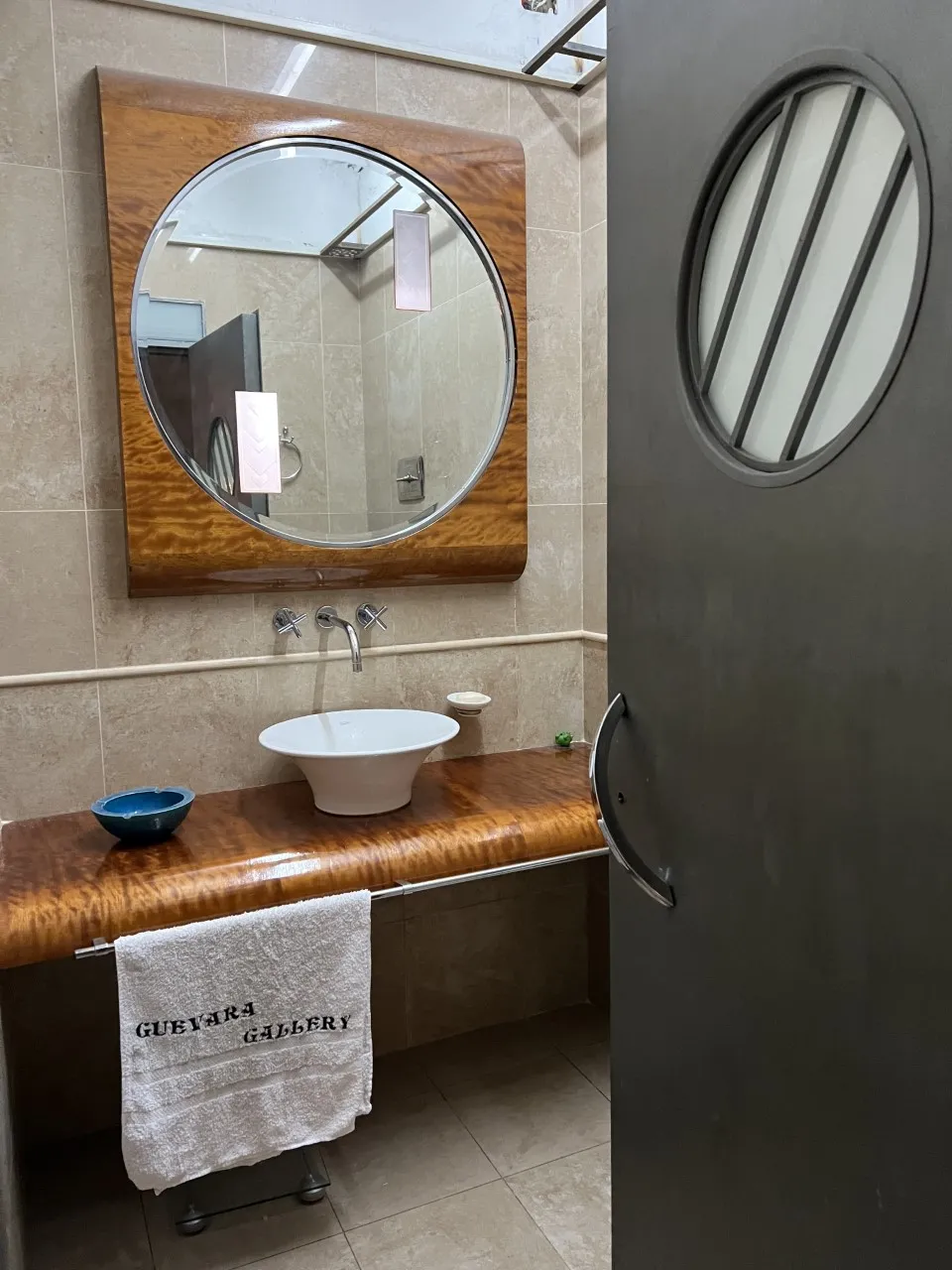 antique round mirror with wooden frame in modern bathroom