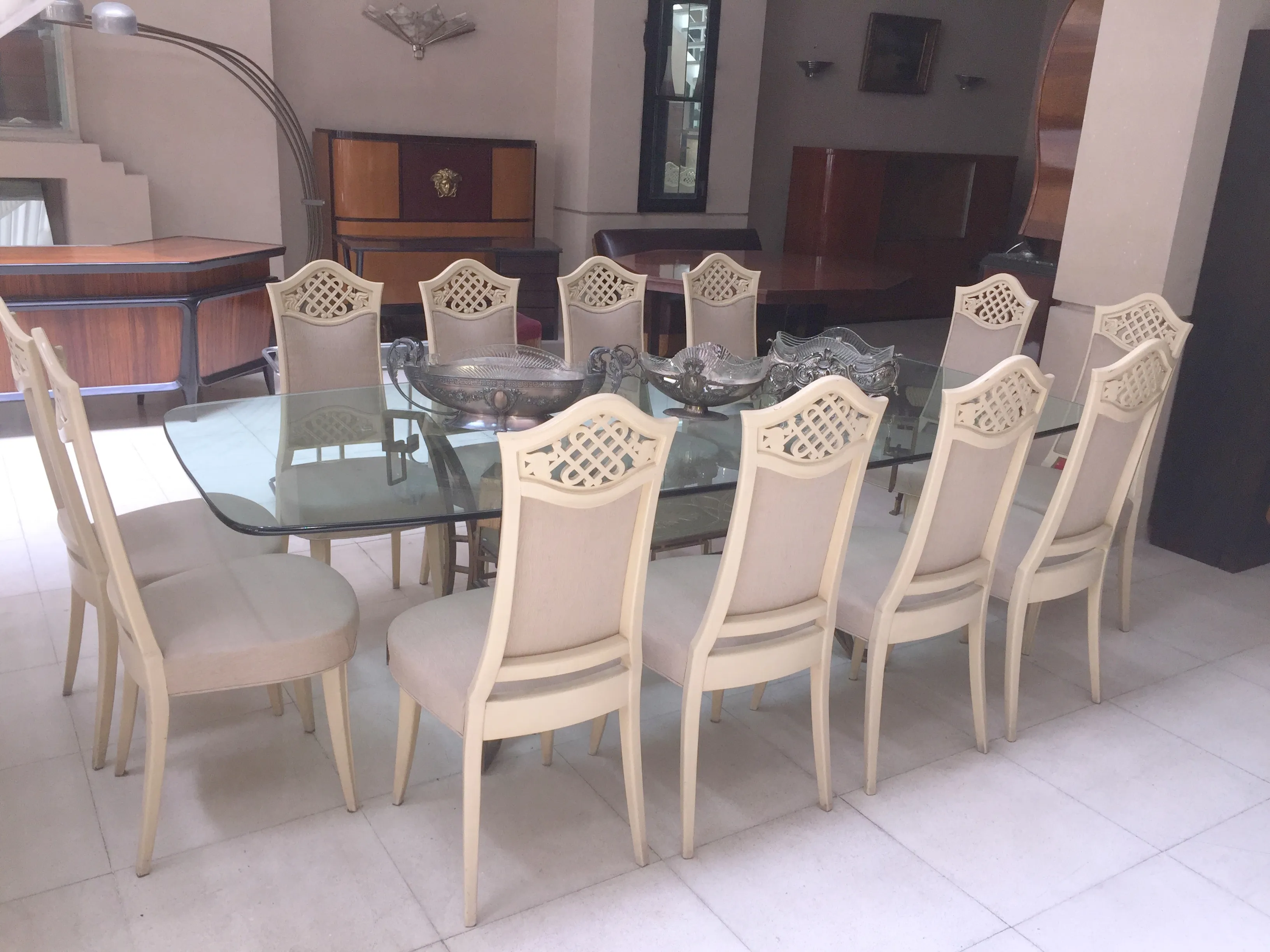 Mesa de jantar antiga para 10 pessoas com cadeiras elegantes.