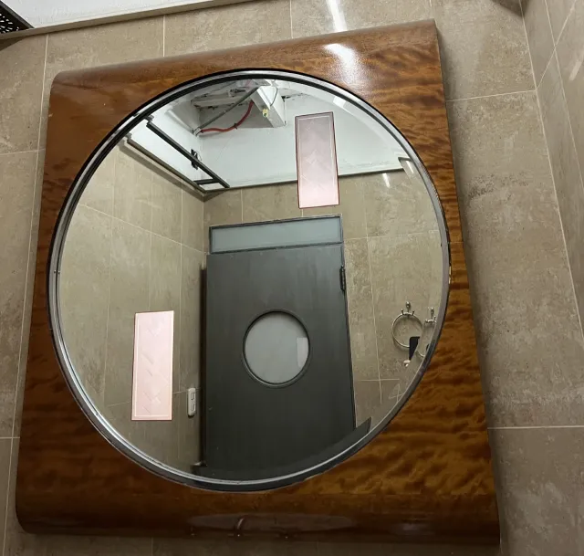 miroir ovale ancien avec cadre décoratif dans une salle de bain