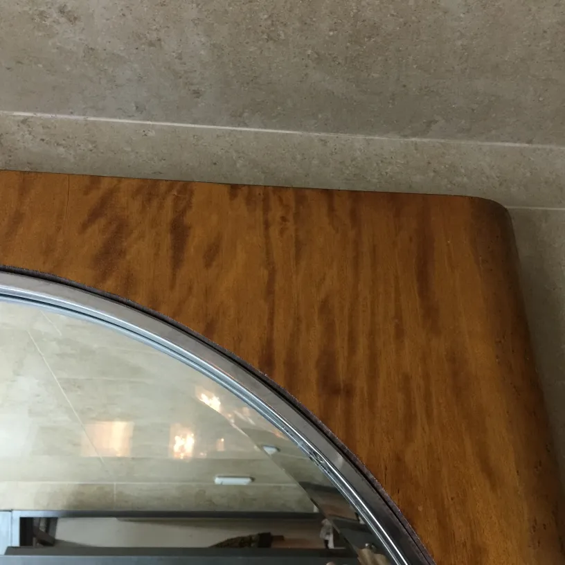 Antique mirror with rounded frame in an elegant setting.