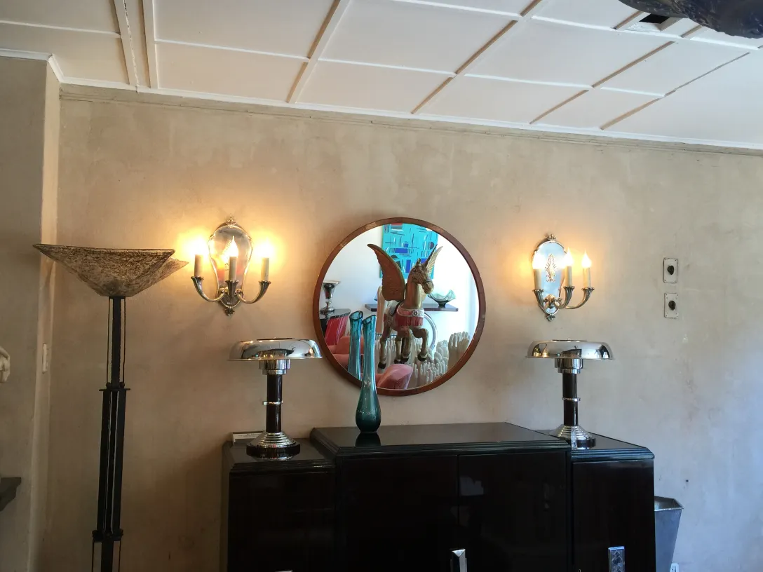 Espelho redondo antigo com detalhes decorativos refletindo um ambiente acolhedor.