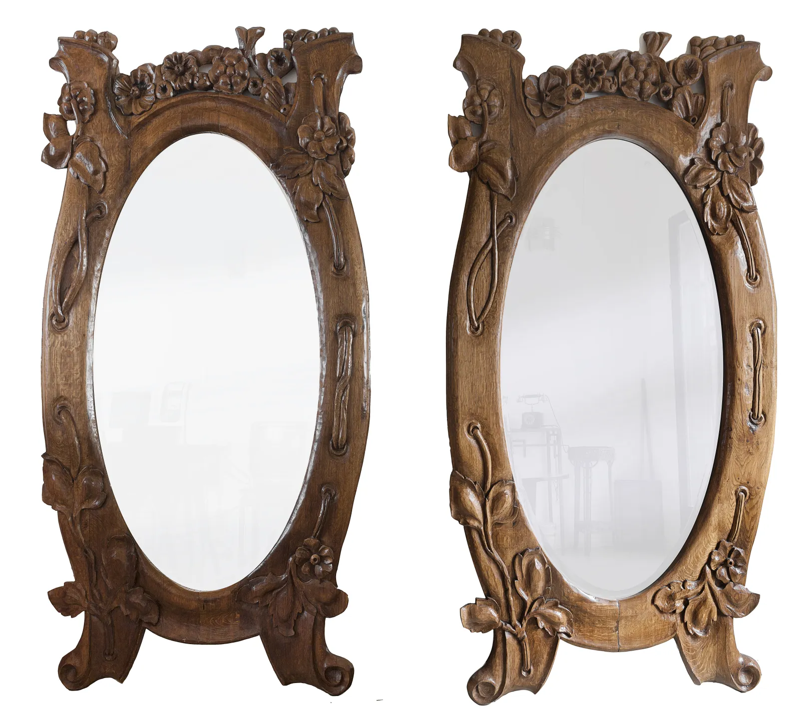 espejo antiguo de forma ovalada con decoraciones florales en madera, ambiente elegante