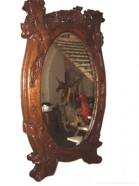 miroir ancien avec des détails floraux, dans un cadre décoratif