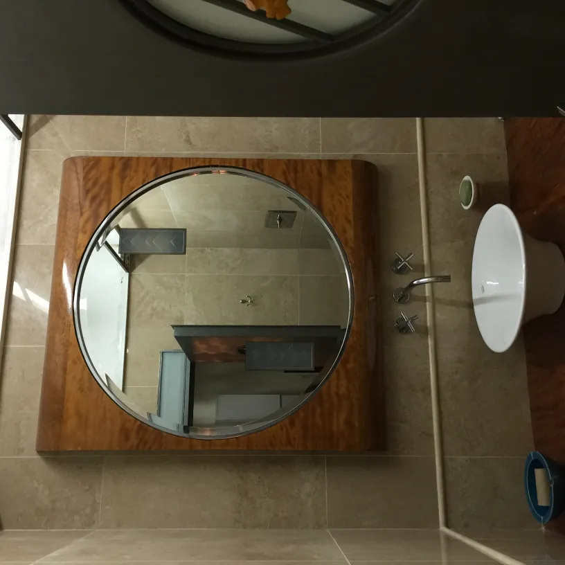 antique round mirror with wooden frame in a modern bathroom