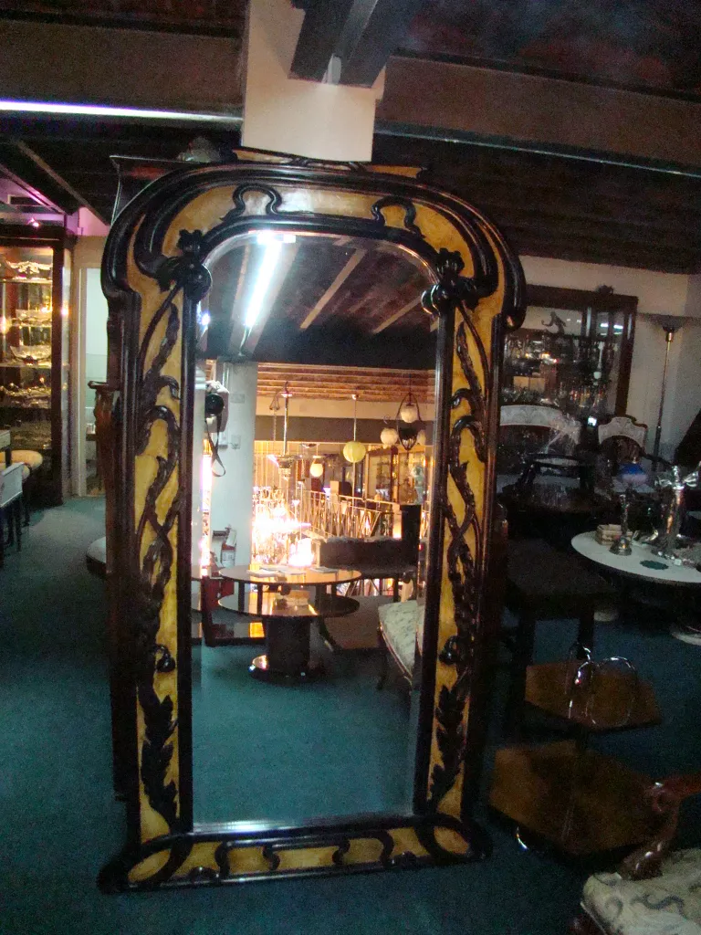 antique decorative mirror with ornate frame in an antique setting, featuring soft lighting and elegant furniture