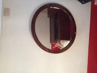 espejo antigo redondo na parede com fundo branco