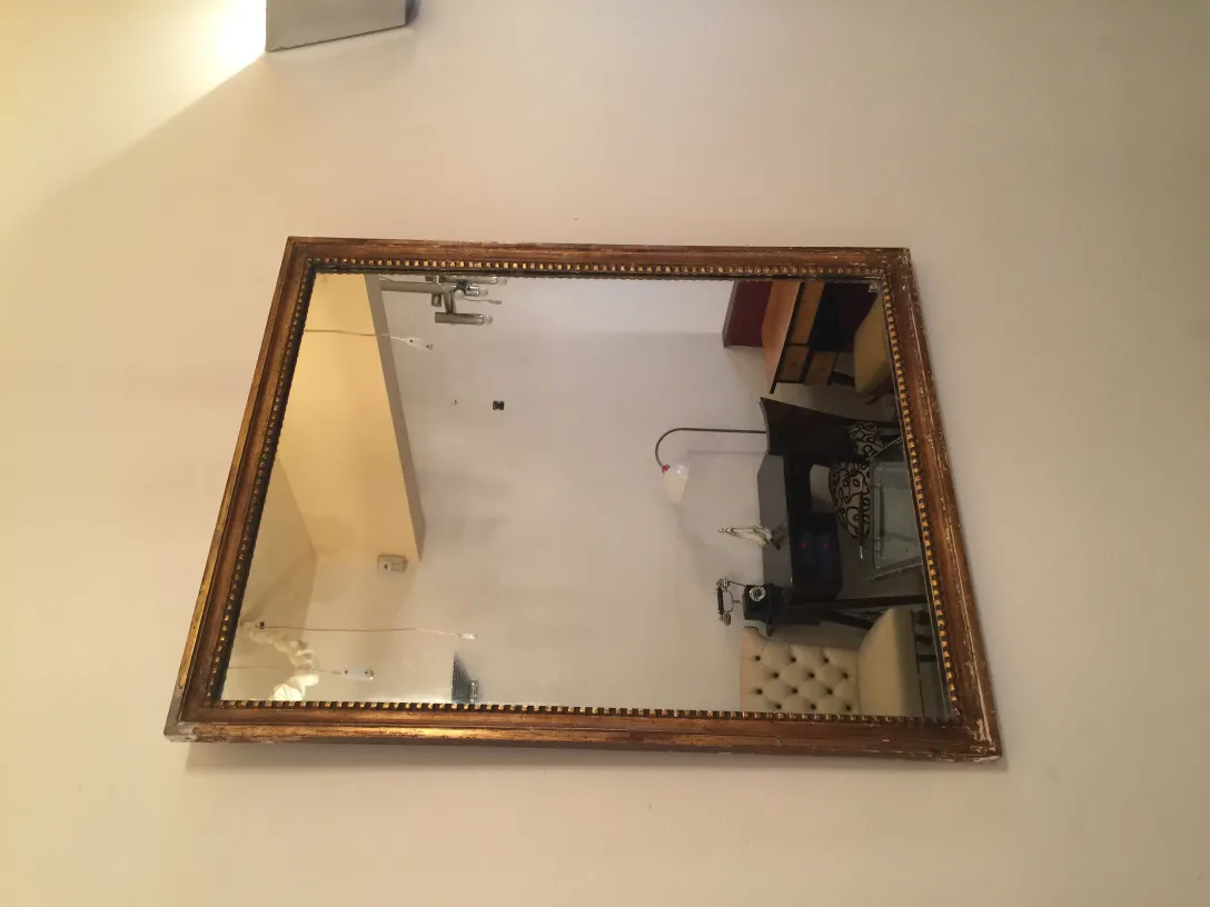 miroir ancien dans un cadre doré accroché au mur