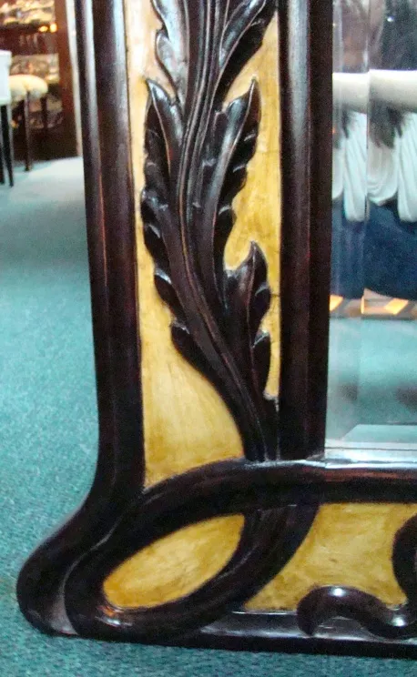 Espelho antigo com moldura esculpida de folhas, fundo suave