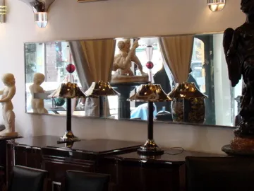 specchio antico in un ambiente elegante con lampade e sculture