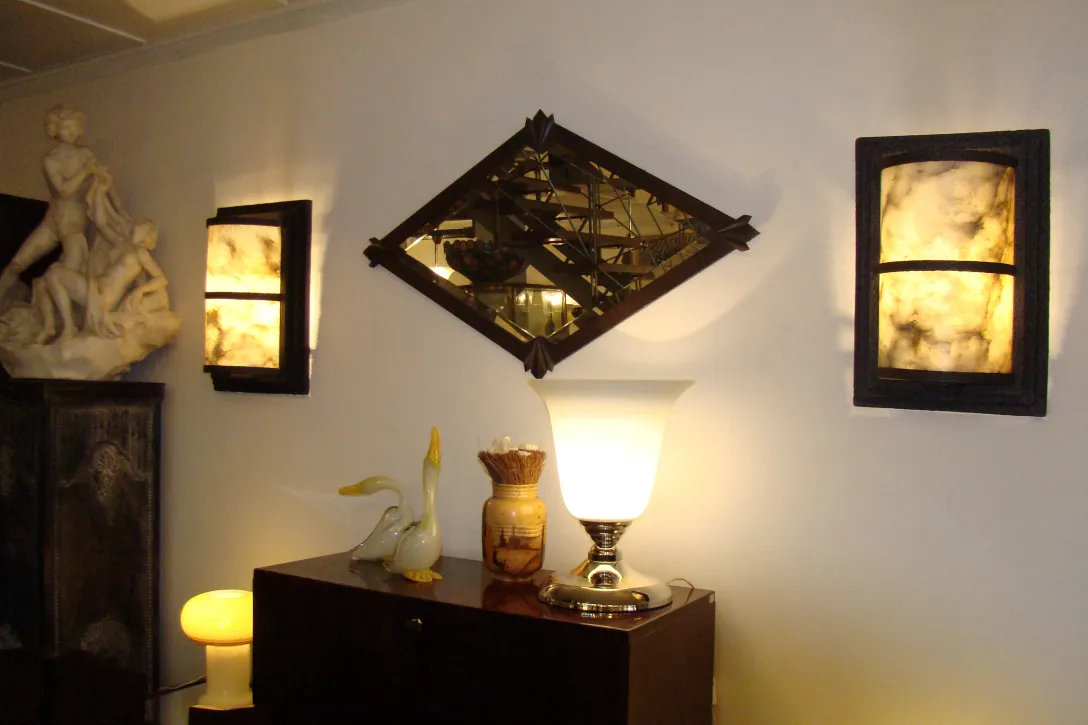 antiguo espejo decorativo con un marco elegante, iluminado por lámparas