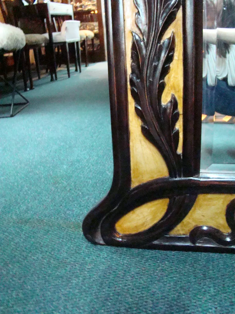 antique mirror with a detailed decorative frame at the bottom, surrounded by a classic atmosphere