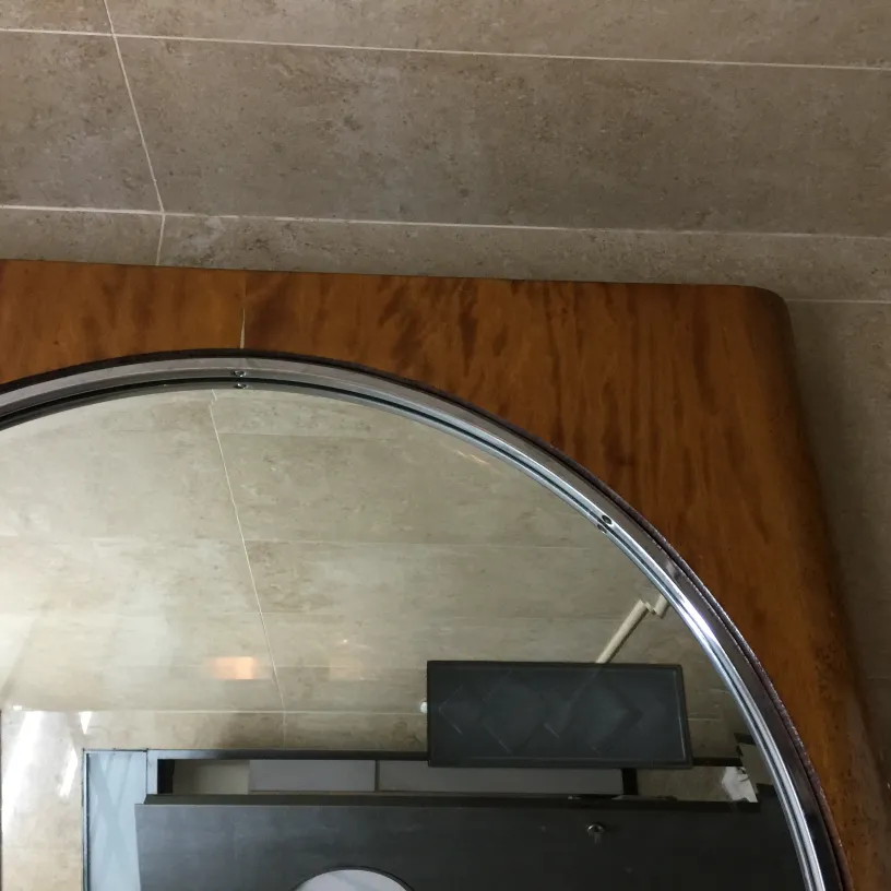 Miroir rond ancien avec bord clair dans un cadre moderne.