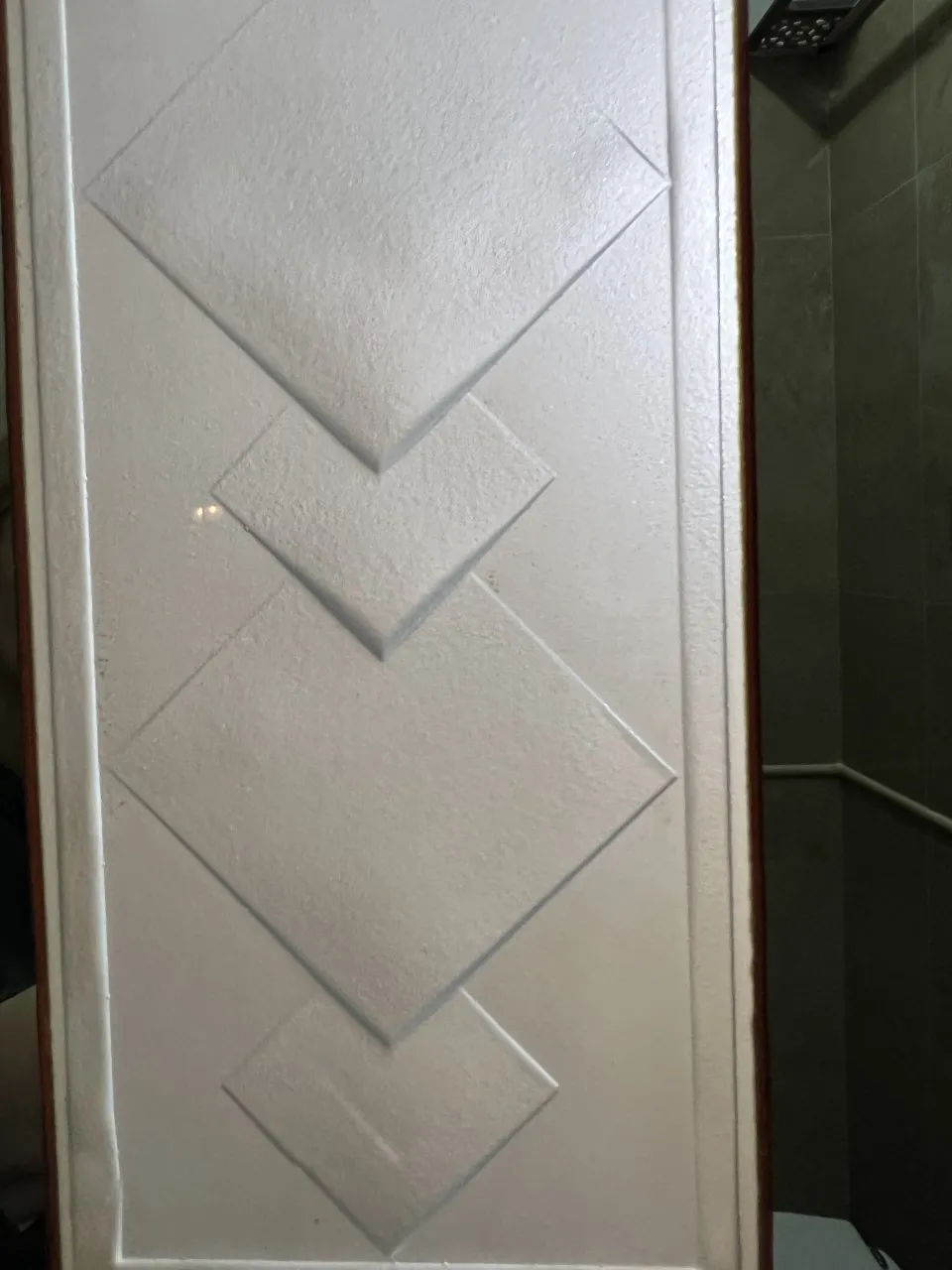 espelho de parede antigo decorado com formas geométricas e fundo branco