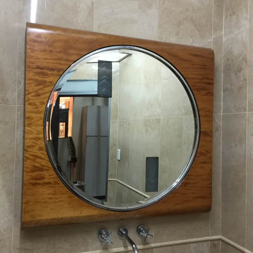antique round mirror with frame in a modern bathroom