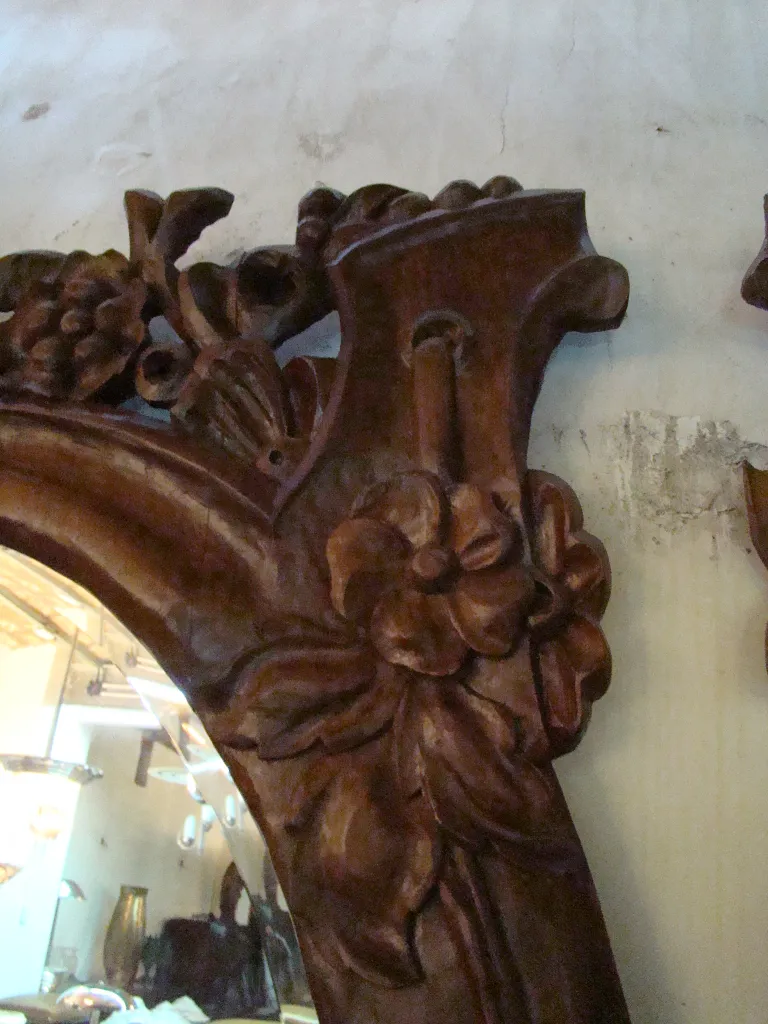 Specchio antico con cornice decorata e motivi floreali