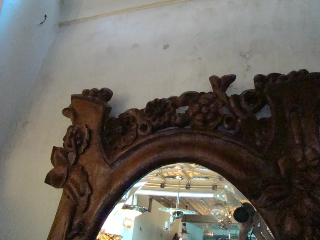 antique mirror with floral decoration against a light background