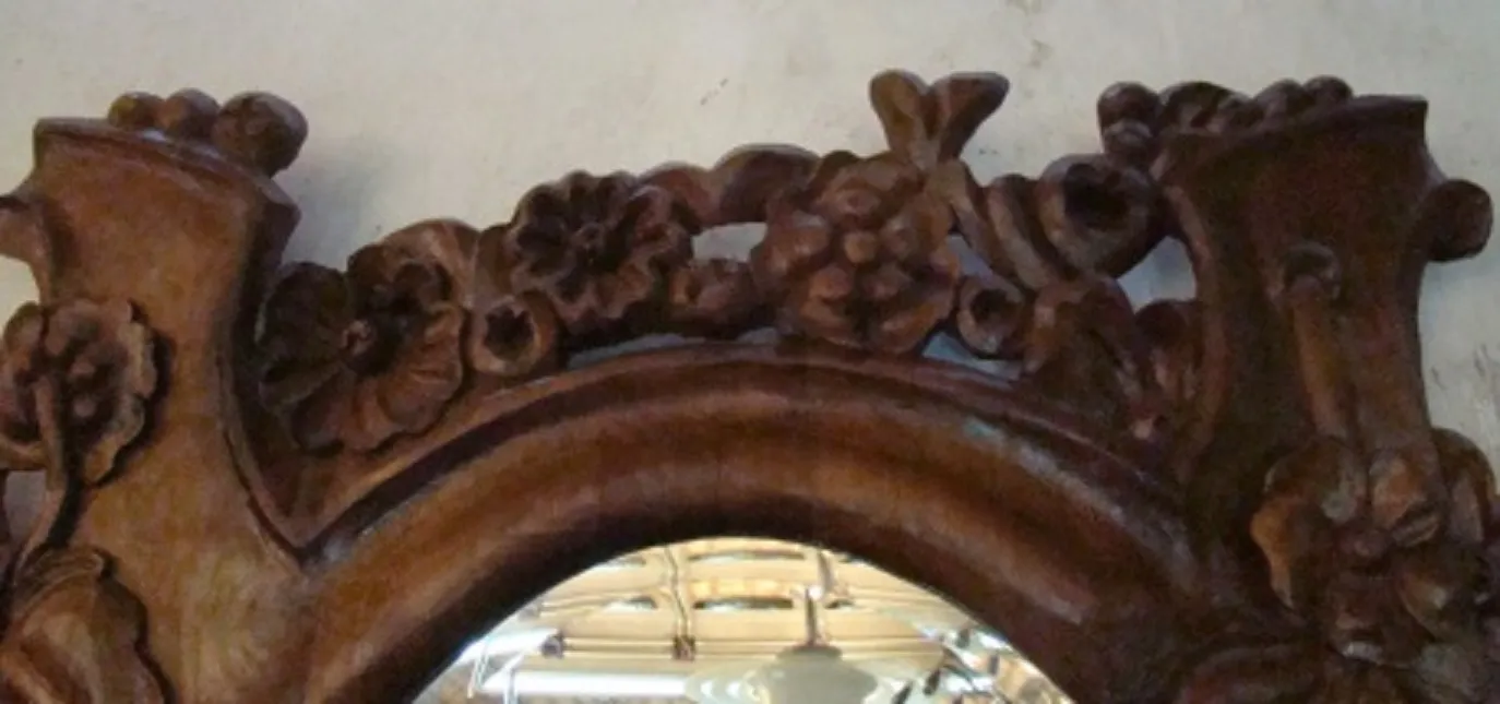 antique mirror adorned with flowers at the top