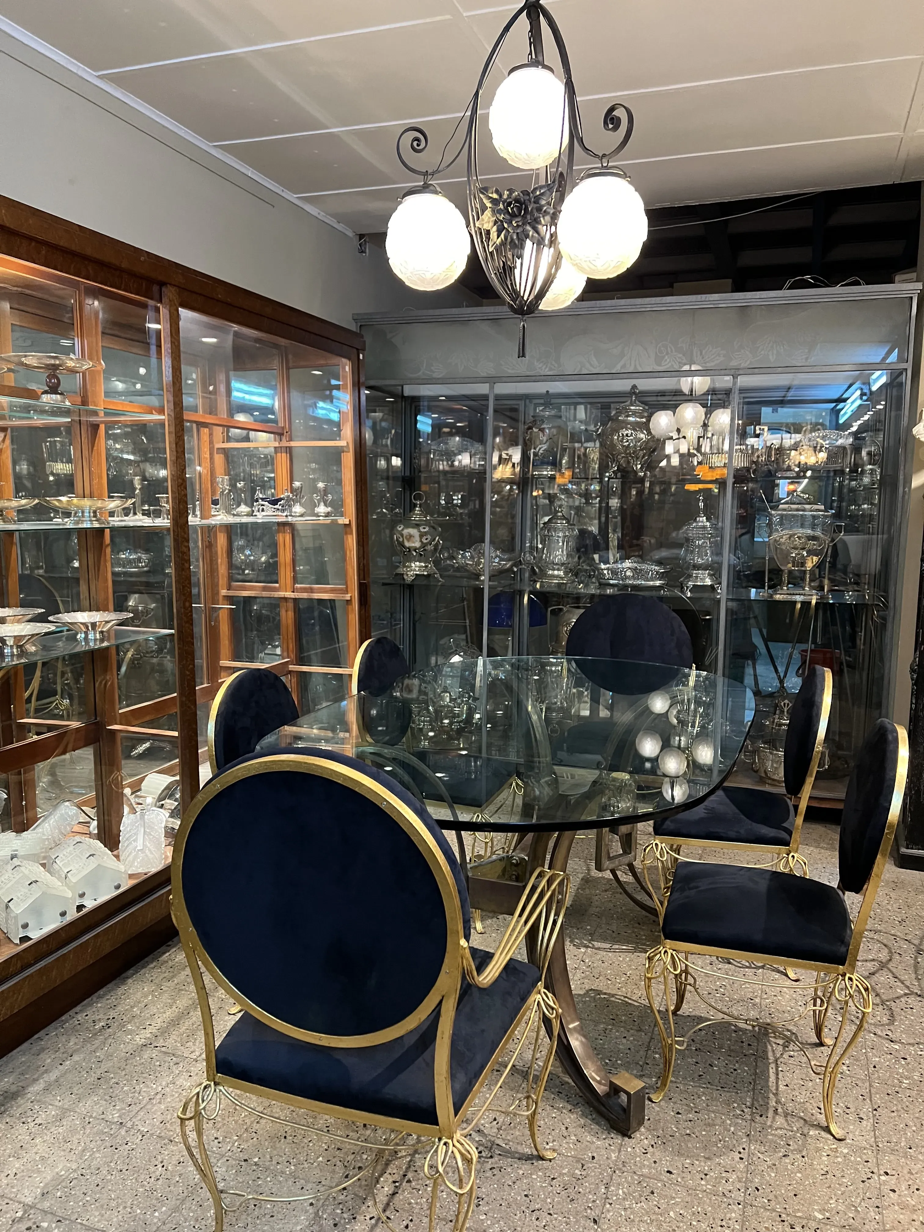 Mesa de comedor antigua con sillas doradas y tapizado azul.