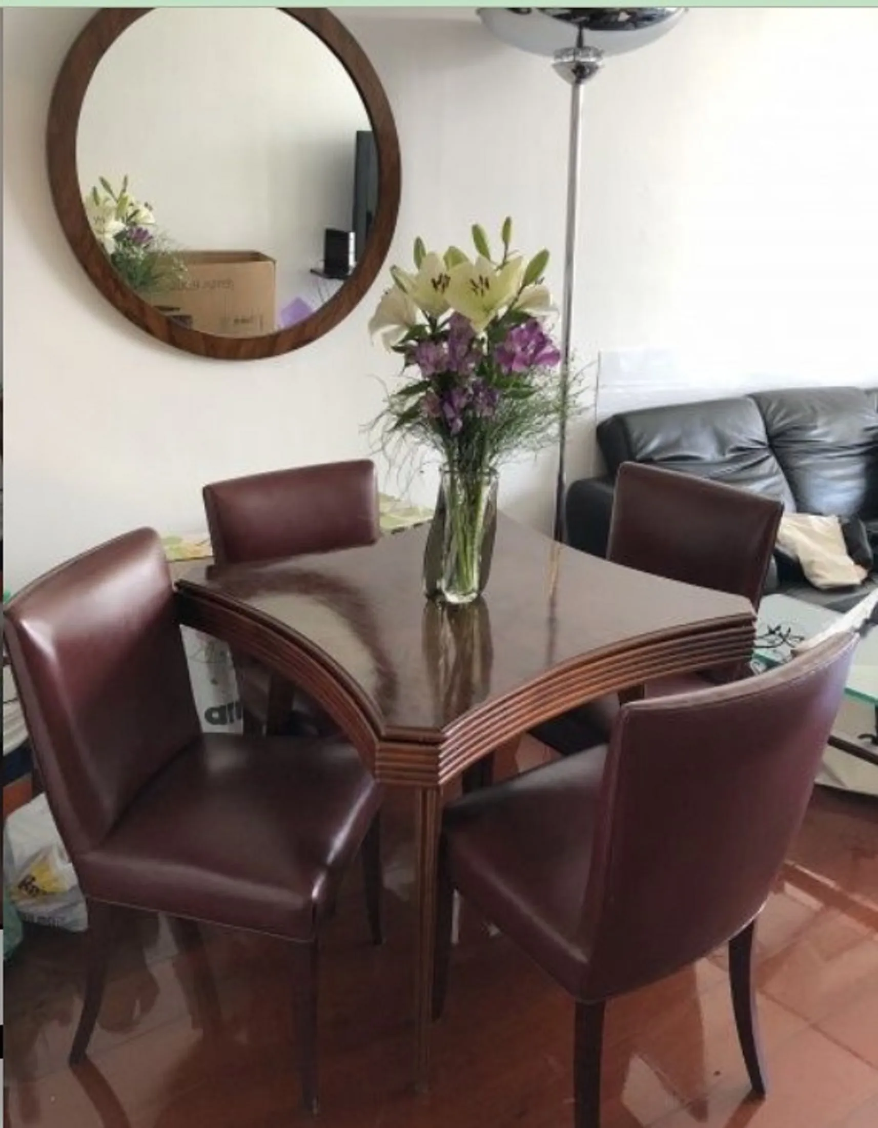 antique table with 4 brown leather chairs and flowers