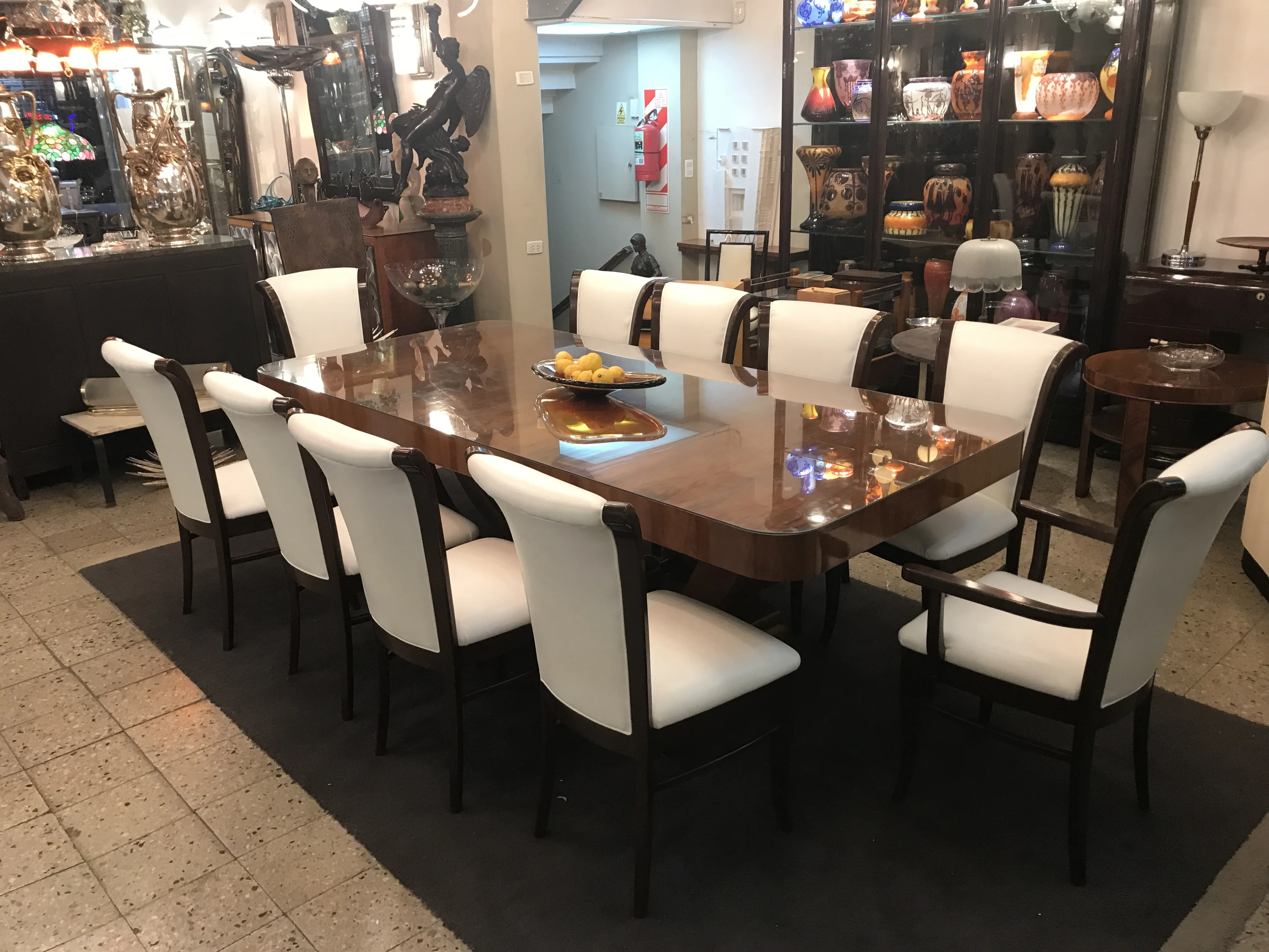 Tavolo da pranzo antico Art Deco per 10 persone con sedie eleganti in un ambiente decorativo.