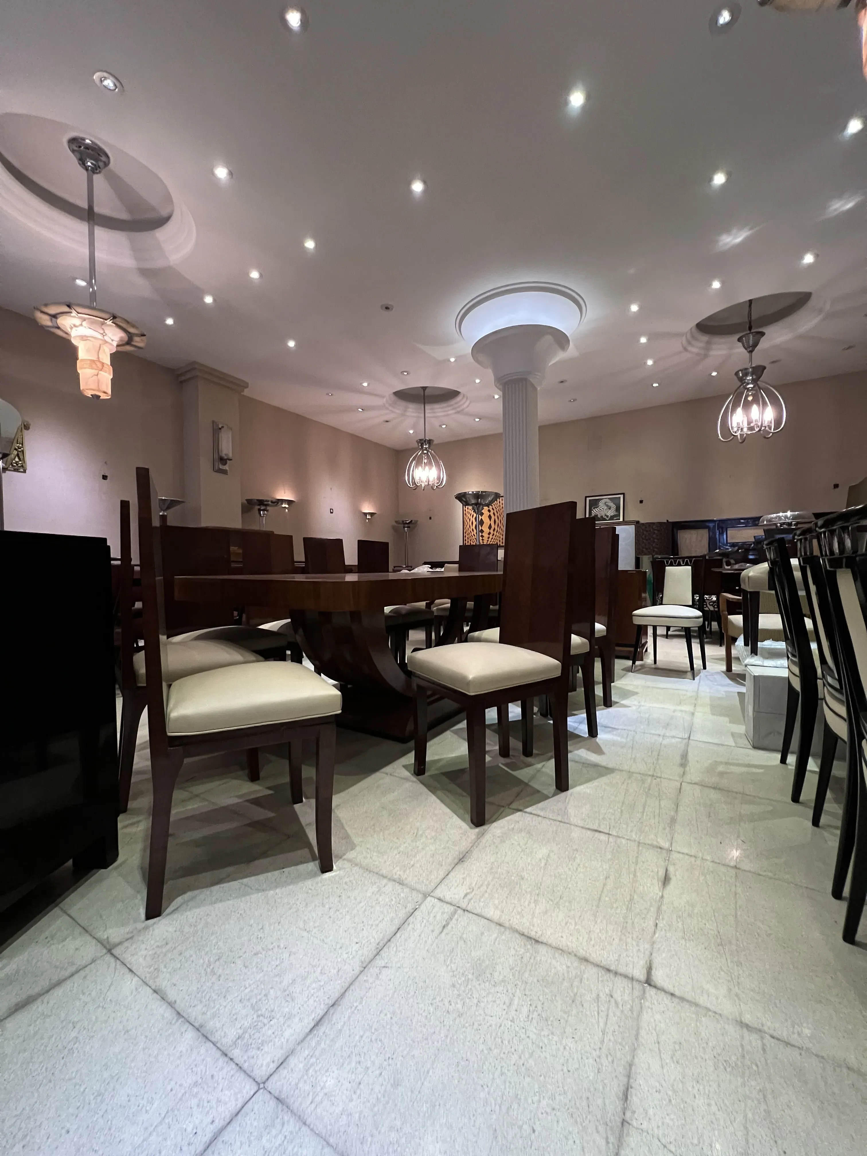 Tavolo da pranzo antico Art Deco per 10 persone, circondato da sedie eleganti.