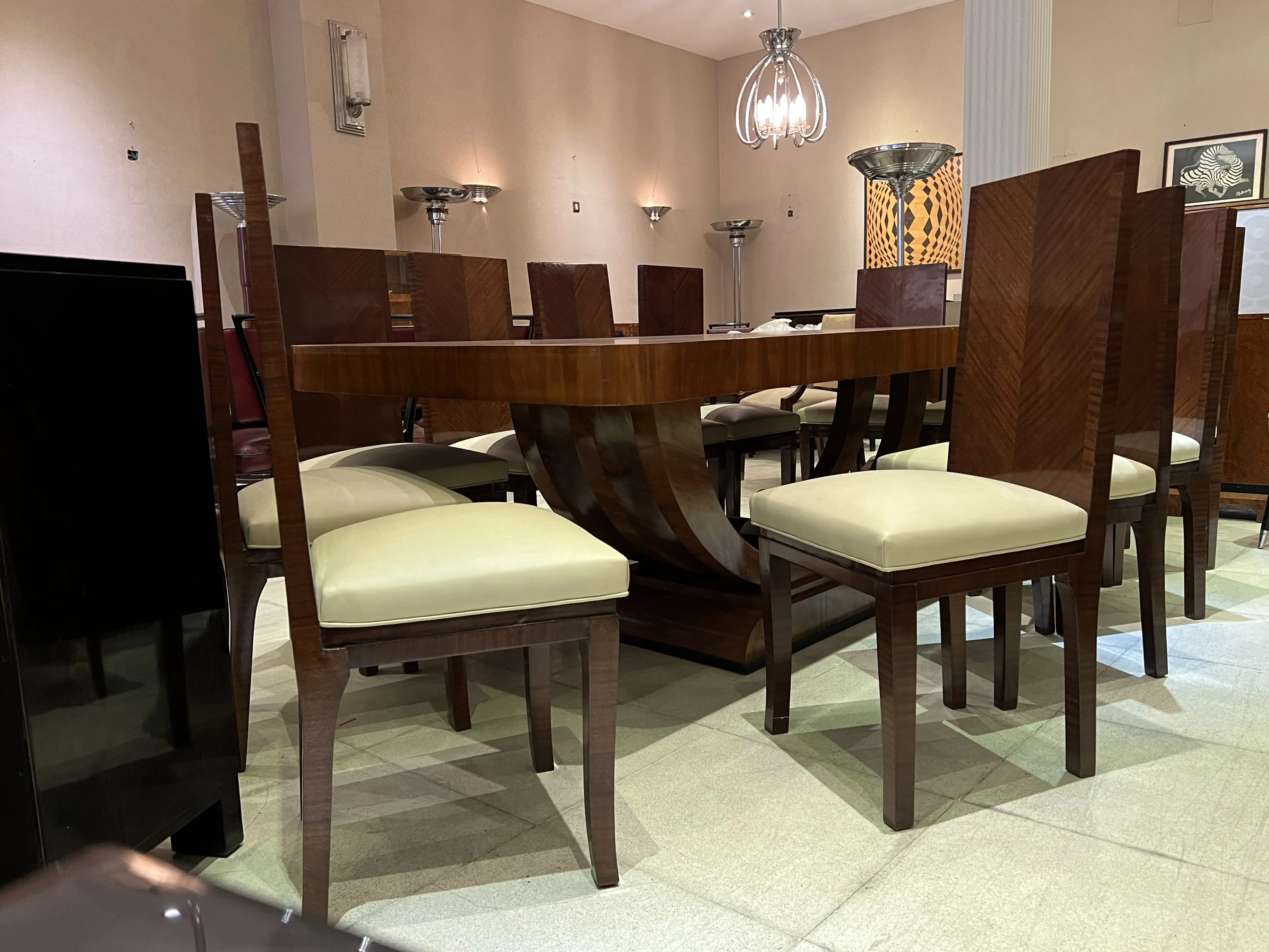 Mesa de comedor antigua para 10 personas en un ambiente elegante con sillas tapizadas.