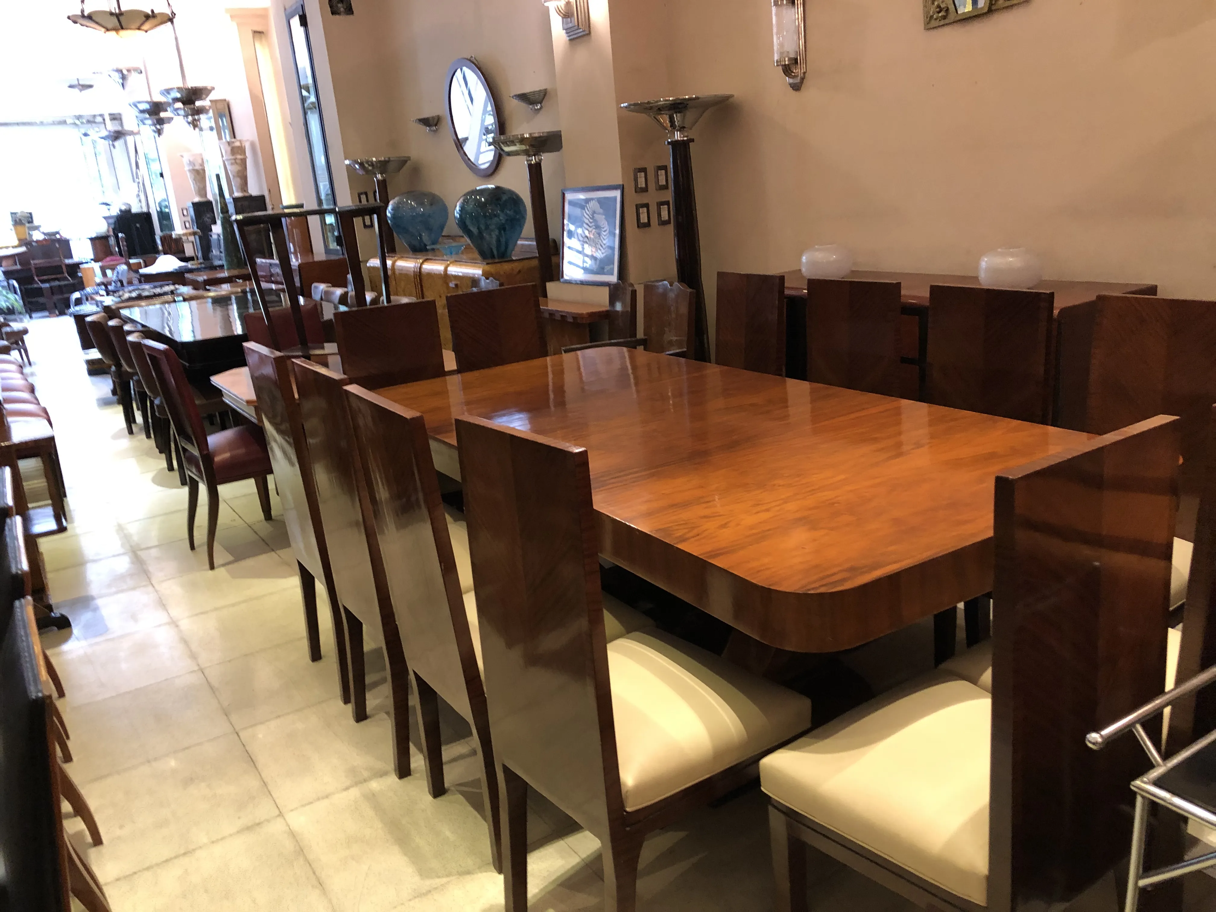 Mesa de comedor antigua para 10 personas rodeada de sillas elegantes.