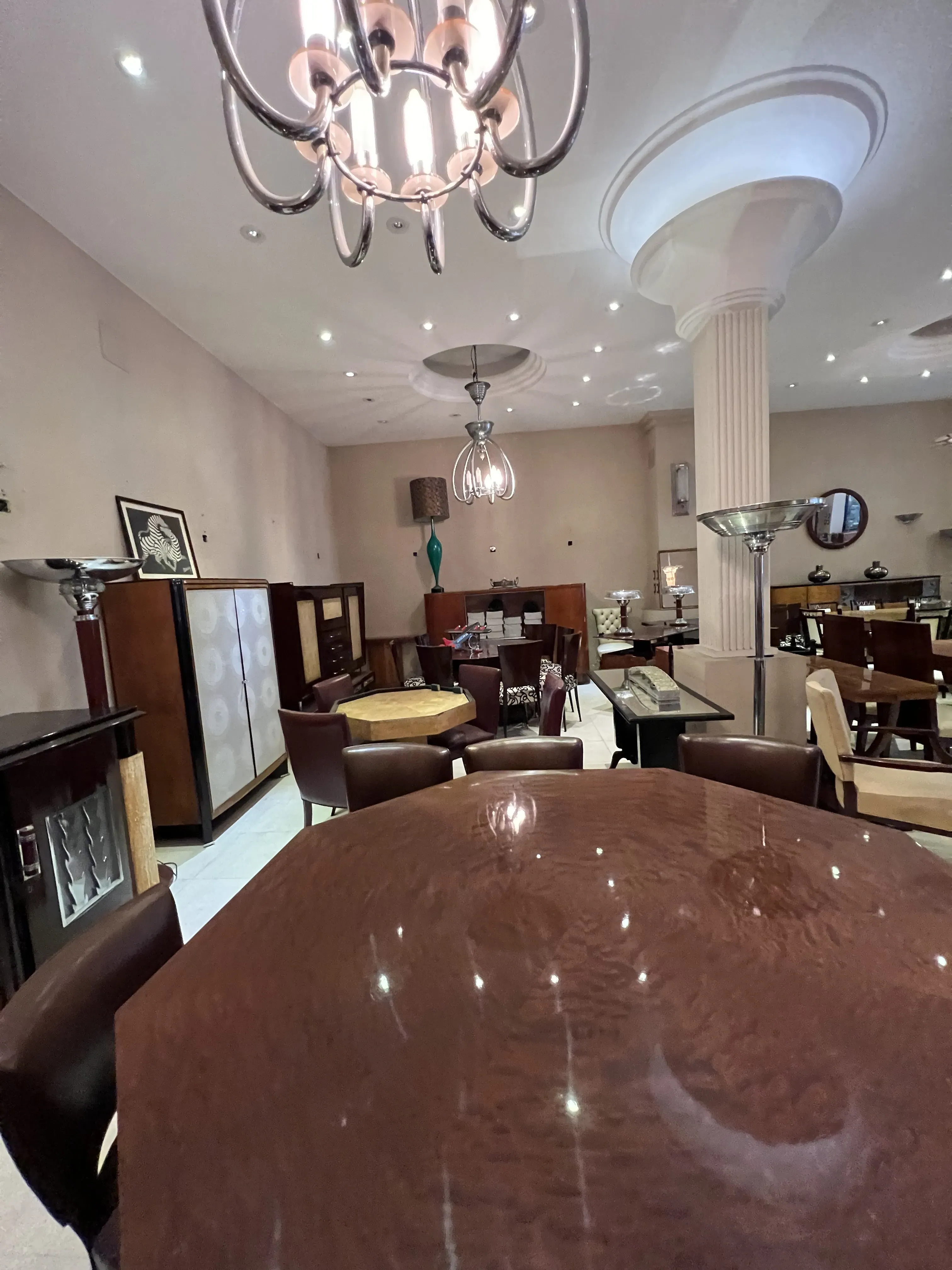 Mesa de jantar antiga com cadeiras em ambiente elegante.