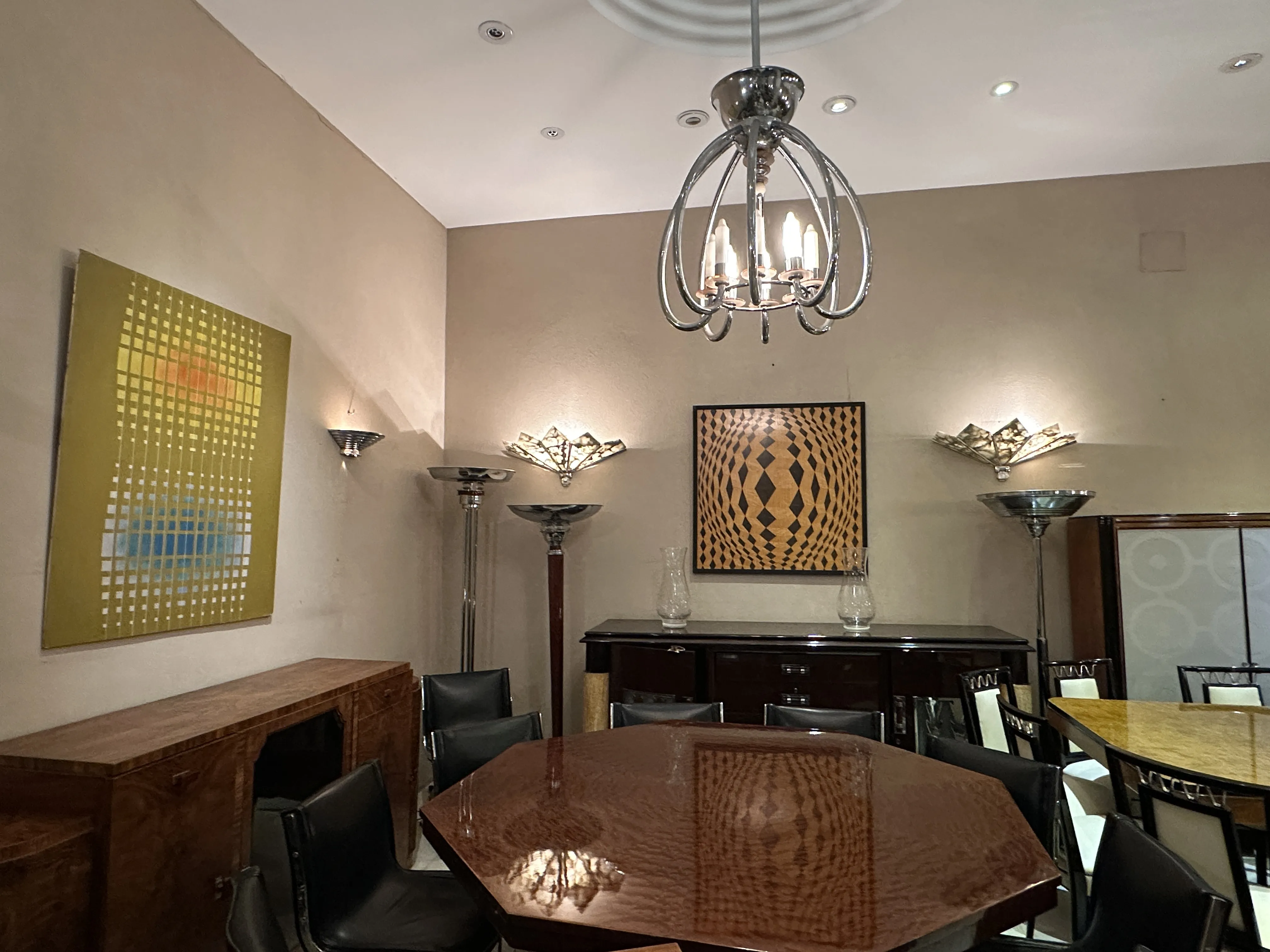 Antique dining table for 8 people, featuring elegant decor, surrounded by chairs in a sophisticated setting.