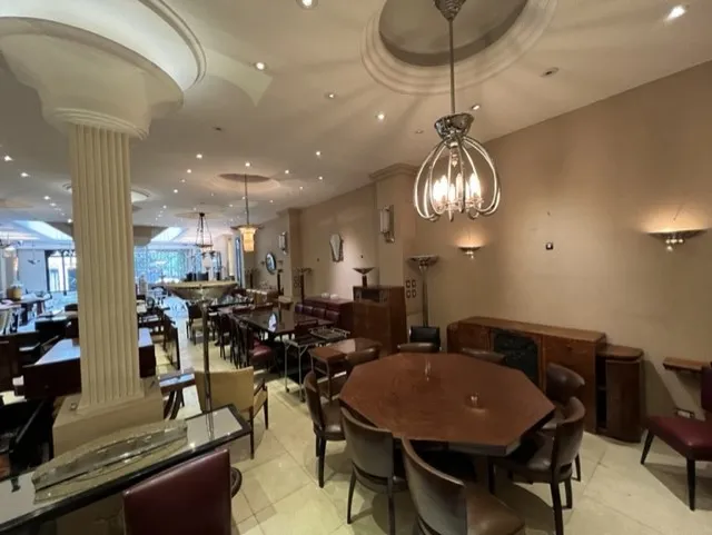 Mesa de jantar antiga para oito pessoas em um ambiente elegante.