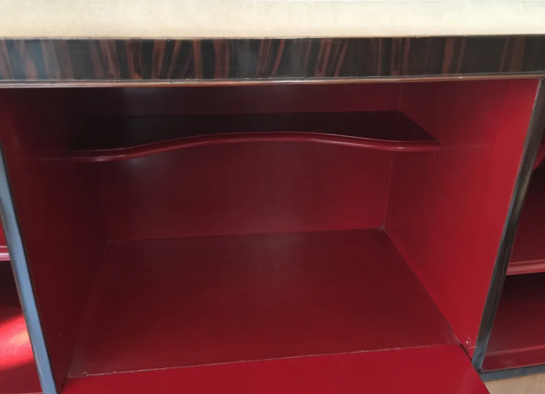 Innenansicht eines antiken Bücherregals mit roten Regalen und eleganten Oberflächen