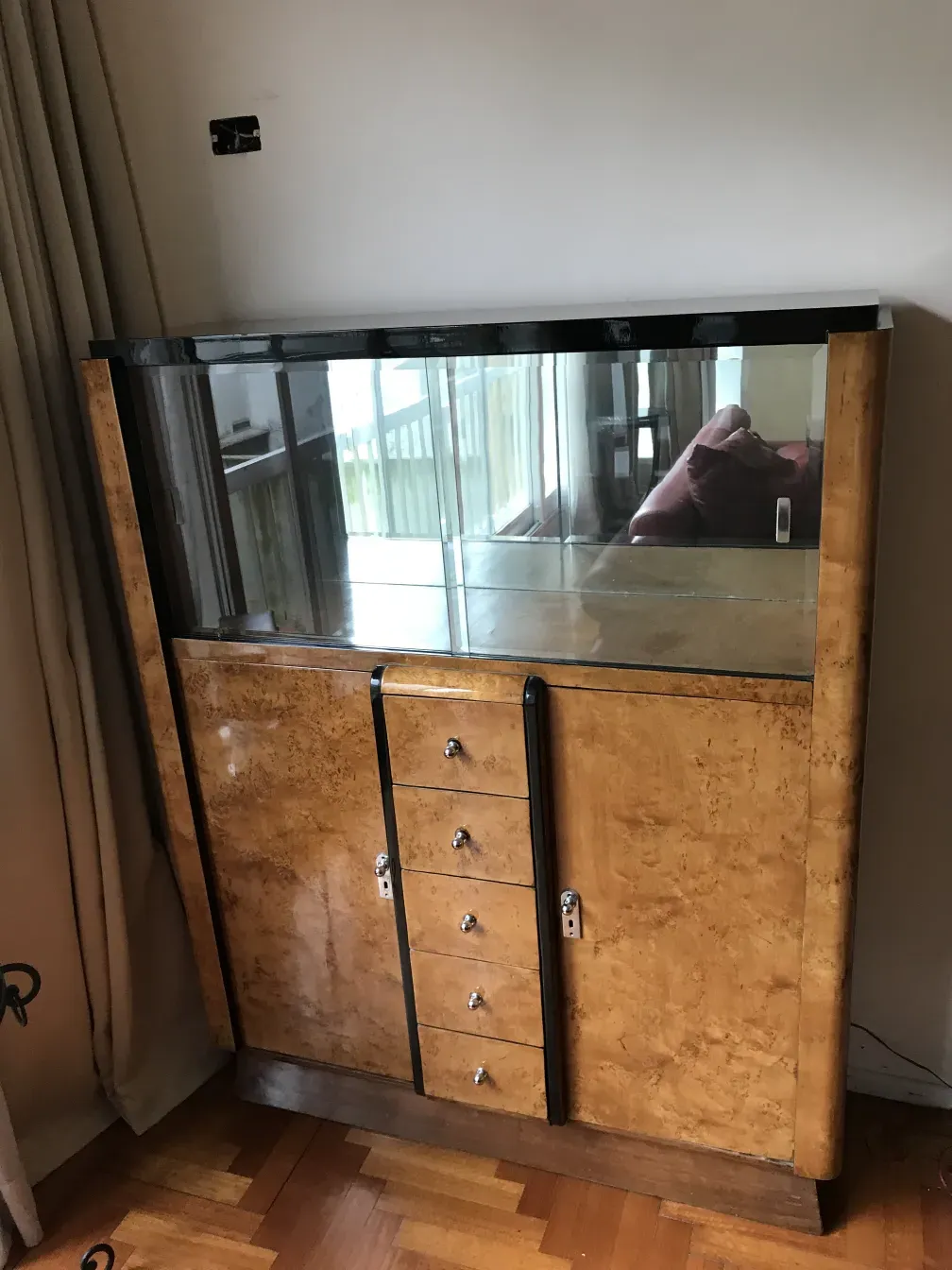 Antikes Bücherregal mit Glasvitrinen und Schubladen, einladende Atmosphäre.