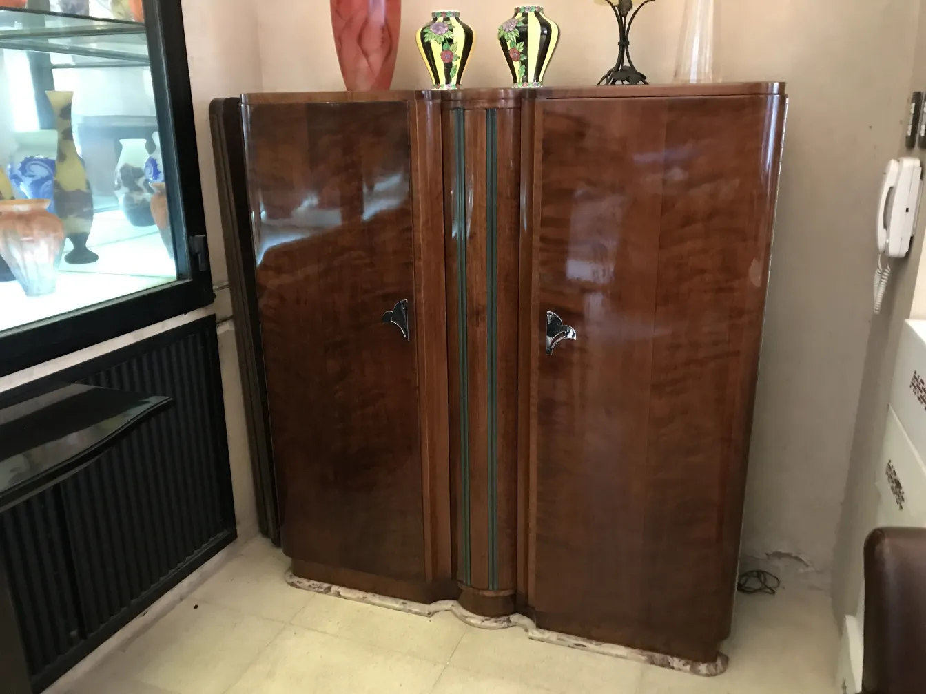 antique bookcase with a glossy finish and decorative details, set in an antique environment