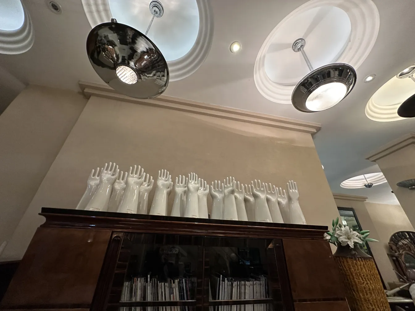 estante de livros antigo com mãos decorativas e luzes modernas