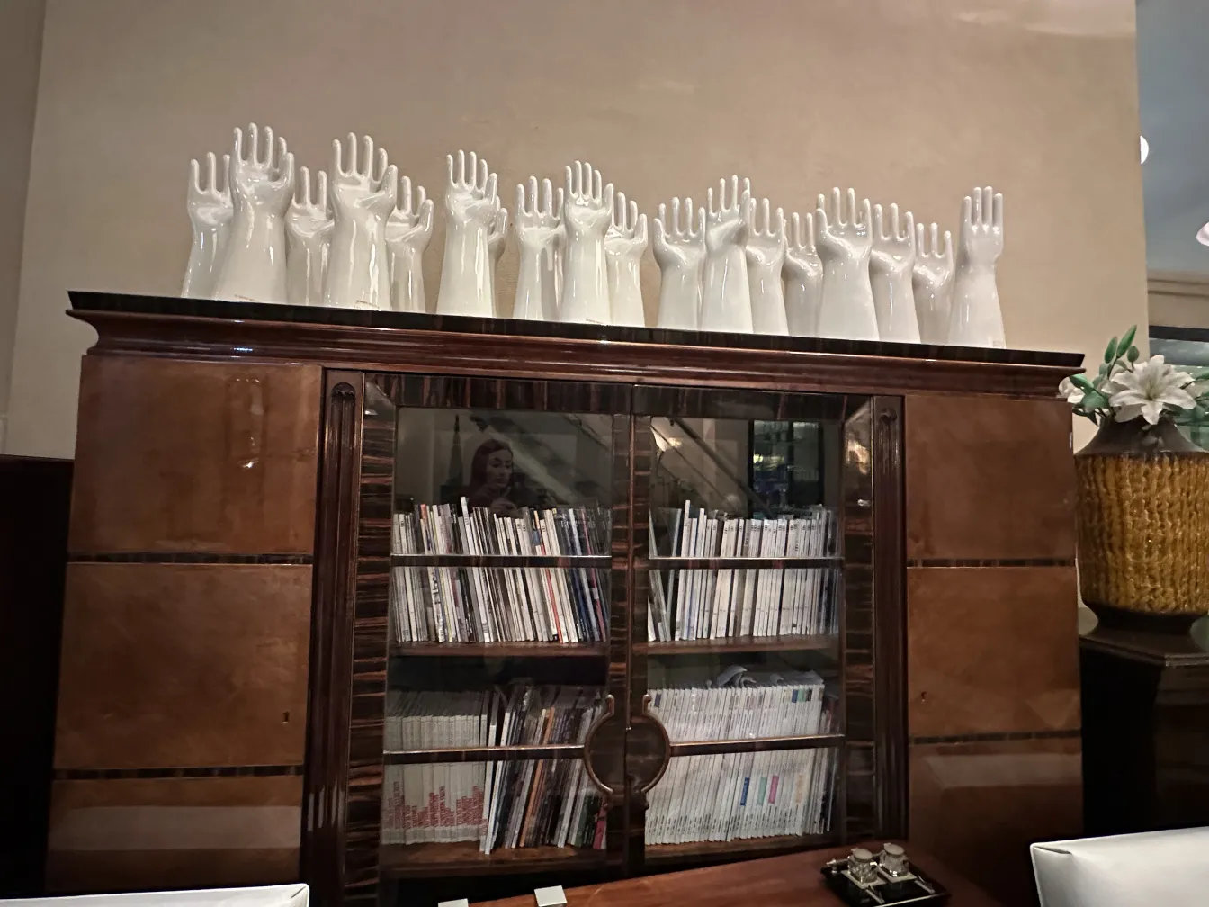 bibliothèque antique avec des mains en céramique et des magazines