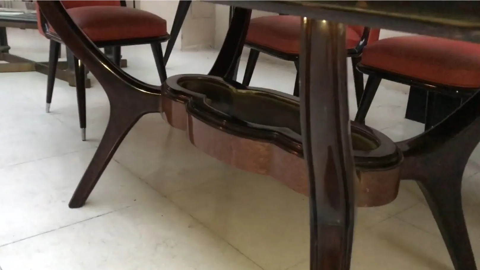 Mesa antiga de jantar para oito pessoas, design elegante, com cadeiras ao redor.