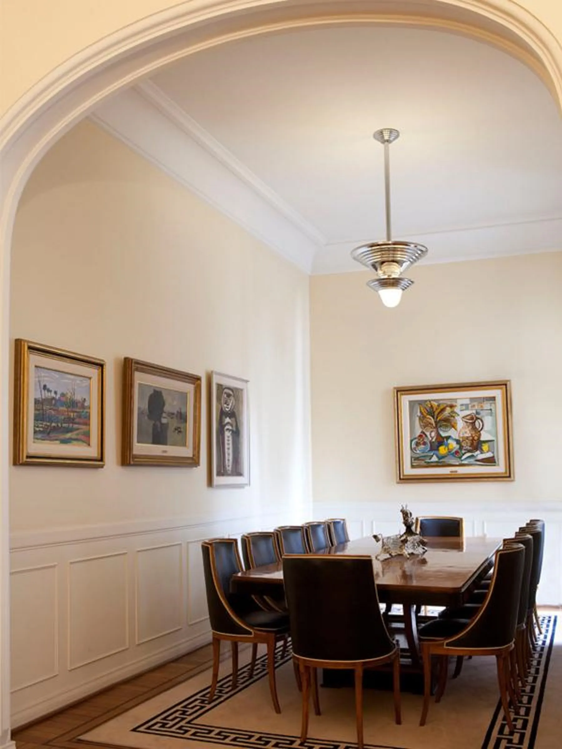 Antique dining table with 12 chairs in an elegant setting.