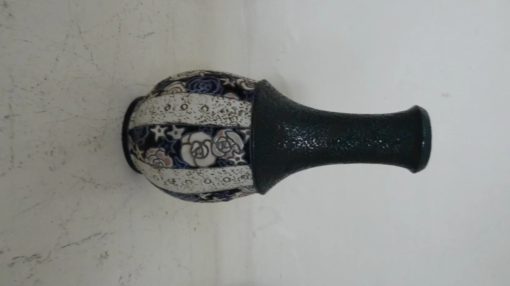 Antique ceramic decorated with floral designs on a light background.