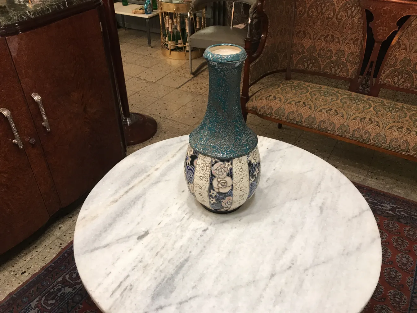 Ânfora decorativa antiga em cerâmica sobre a mesa de mármore.