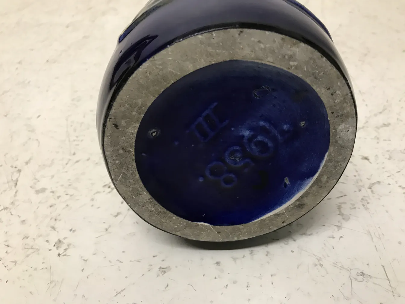 바닥에 세부 사항이 있는 오래된 파란 도자기, 밝은 배경.